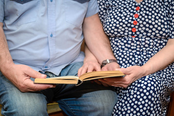 Elderly couple reading a book together closeup