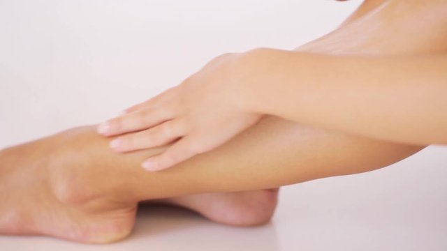 woman applying moisturizing cream to her leg