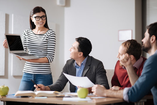 Positive delighted woman showing her presentation to colleagues