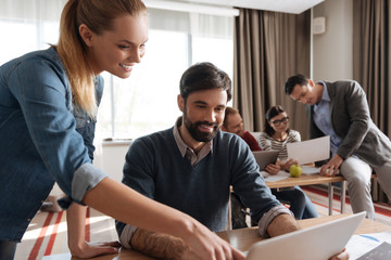 Portrait of smiling woman while helping to her colleague