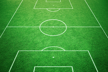 Fototapeta na wymiar Soccer playfield ground lines on sunny grass background. Goal side perspective used.