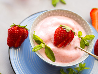 Home made strawberry ice cream in bowl with min leaves