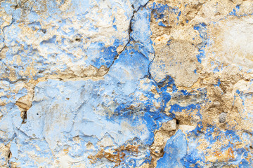 Old stone rustic cracked wall painted in blue paint as decay texture background