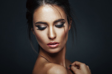 Beauty portrait of a young woman in the studio on a dark background