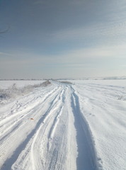 Fototapeta na wymiar Road in snowy field