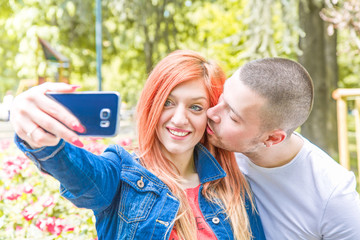 giovane coppia che si fa un selfie al parco