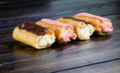 Eclairs on dark wooden background