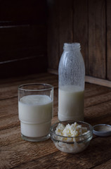 Sour-dairy drink or yoghurt in bottle that come from the kefir grains and milk on wooden background. Photographed with natural light