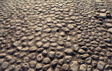 A wide street lined with paving stones.

