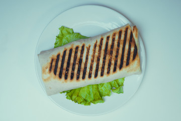 Shaurma grilled with chicken, French fries on a salad leaf. fast food
