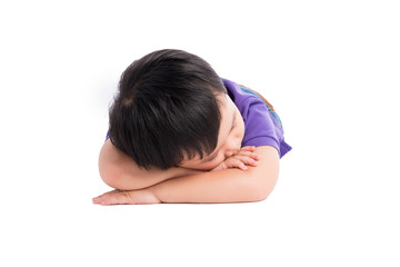 Obraz premium Tired kid boy lying on the ground with his face down