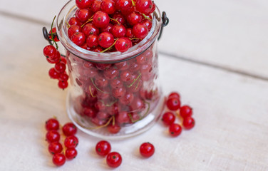 Fresh red currant on a light wooden background 