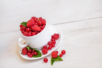 Fresh red currant on a light wooden background