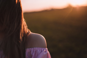 Beautiful young woman with a bouquet of lavender and dreaming in the sunset rays