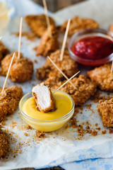 Chicken nuggets on the serviette with yellow and red sauces