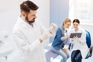 Obraz premium Handsome male doctor holding a special bottle