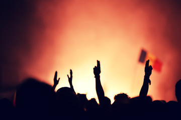 Crowd at a music concert, audience raising hands up