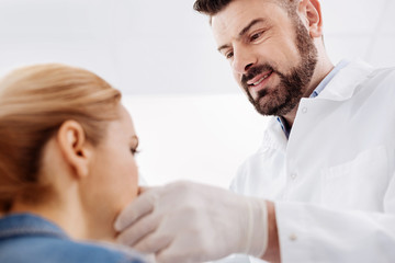Fototapeta premium Cheerful joyful doctor looking at his patient