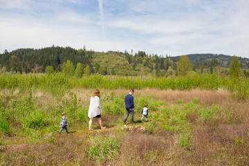 Family Walking Across Field on Trail