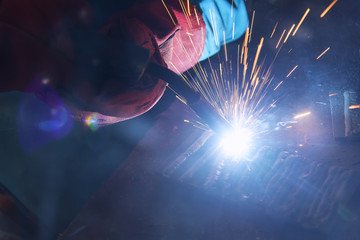 the welding spark light in close-up scene,the torch of welging machine with the spark light in blue