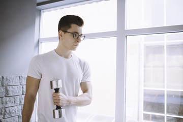 Young sportsman doing workout with dumbbell