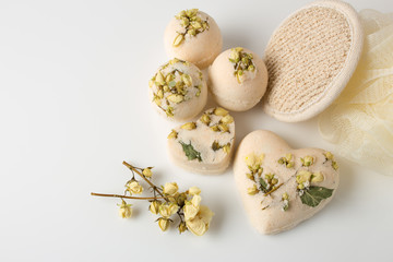 Bath bombs decorated with dried linden flowers on a white