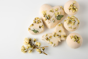 Fototapeta na wymiar Bath bombs decorated with dried linden flowers on a white