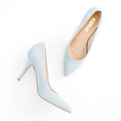 Beauty blog concept. Pale blue female shoes on white background. Flat lay, top view trendy fashion feminine background.