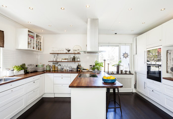 fancy kitchen interior with dark wooden floor and white cupboards