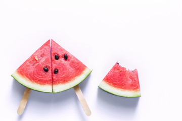 Watermelon sliced into a slice of wood on an white background.