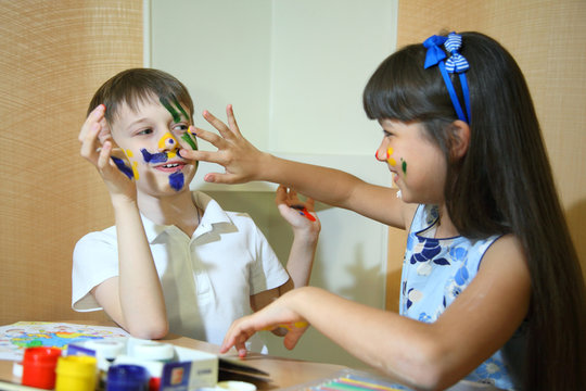 Joyful children with paints on their faces. Creativity and education concept.