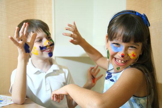 Joyful children with paints on their faces. Creativity and education concept. 