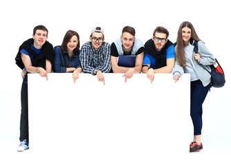 Full length portrait of confident college students displaying blank billboard against white...
