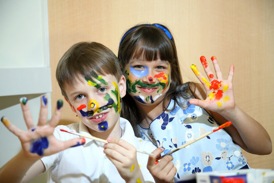 Joyful children with paints on their faces.