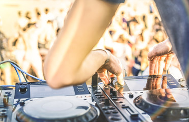 Close up of dj playing electro sound on modern cd usb player at summer beach party - Music festival and entertainment concept  - Defocused background with shallow depth of field - Focus on mixing hand