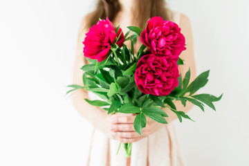 Happy young woman holding in hands peony bouquet. Sweet romantic moment