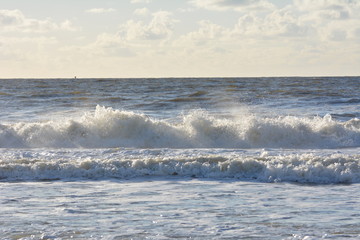 Naklejka na ściany i meble The beach of northern sea with waves splashing at the shore