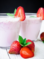 Blueberry smoothie with strawberry on wooden background. Flat lay. Top view. Fresh milkshake