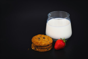 cookies and a glass of milk on black background 