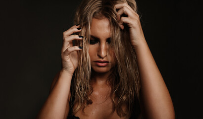 Obraz premium Beautiful young woman posing on black background