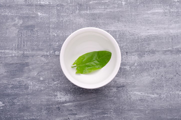 Spring greens for health.  Fresh sorrel in a dish on grey wooden table.