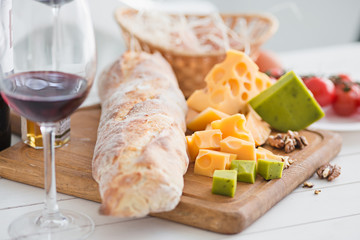 Wine, baguette and cheese on wooden background