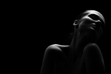 belle femme seins nus aux yeux fermés sur fond noir monochrome