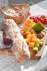 Wine, baguette and cheese on wooden background