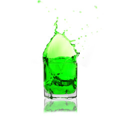 green cocktail splashing on a glass on white background