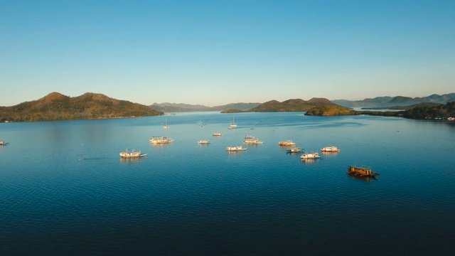 Seascape tropical bay with boats, surrounded by mountains on the island. Aerial view: Beautiful tropical sea bay. Scenic landscape with mountain islands and blue lagoon. Coron, Philippines,Palawan