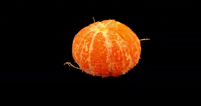 Satsuma / orange peeling itself to reveal fresh juicy fruit. Healthy eating concept filmed in stop motion