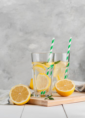 Fresh citrus lemonade in the glasses,concrete grey background, place for text.