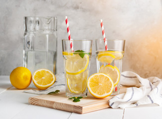 Fresh citrus lemonade in the glasses,concrete grey background,sunlight