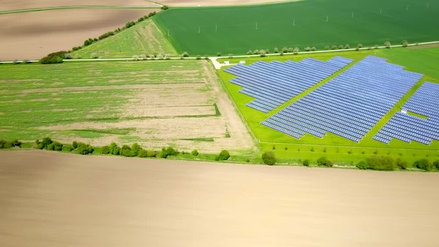 Aerial view of solar power plant in a middle of agriculture landscape.